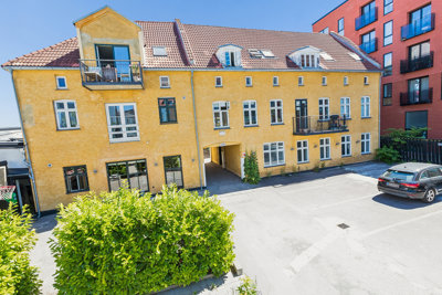 Charmerende pakhusbygning tilbagetrukket fra vejen og med hyggeligt gårdmiljø